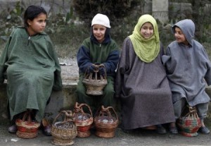 Kashmiri children warm themselves using "Kangris", or traditional fire pots, as they sit outside a polling station on a cold winter morning